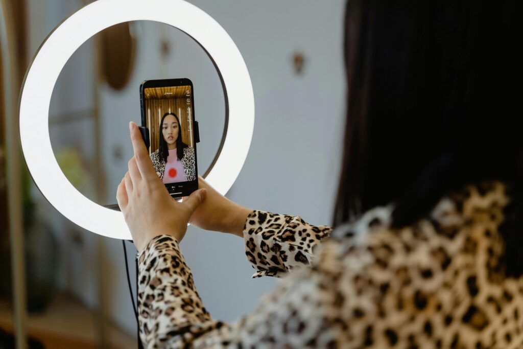 Criadora de conteudo com smartphone e ring light